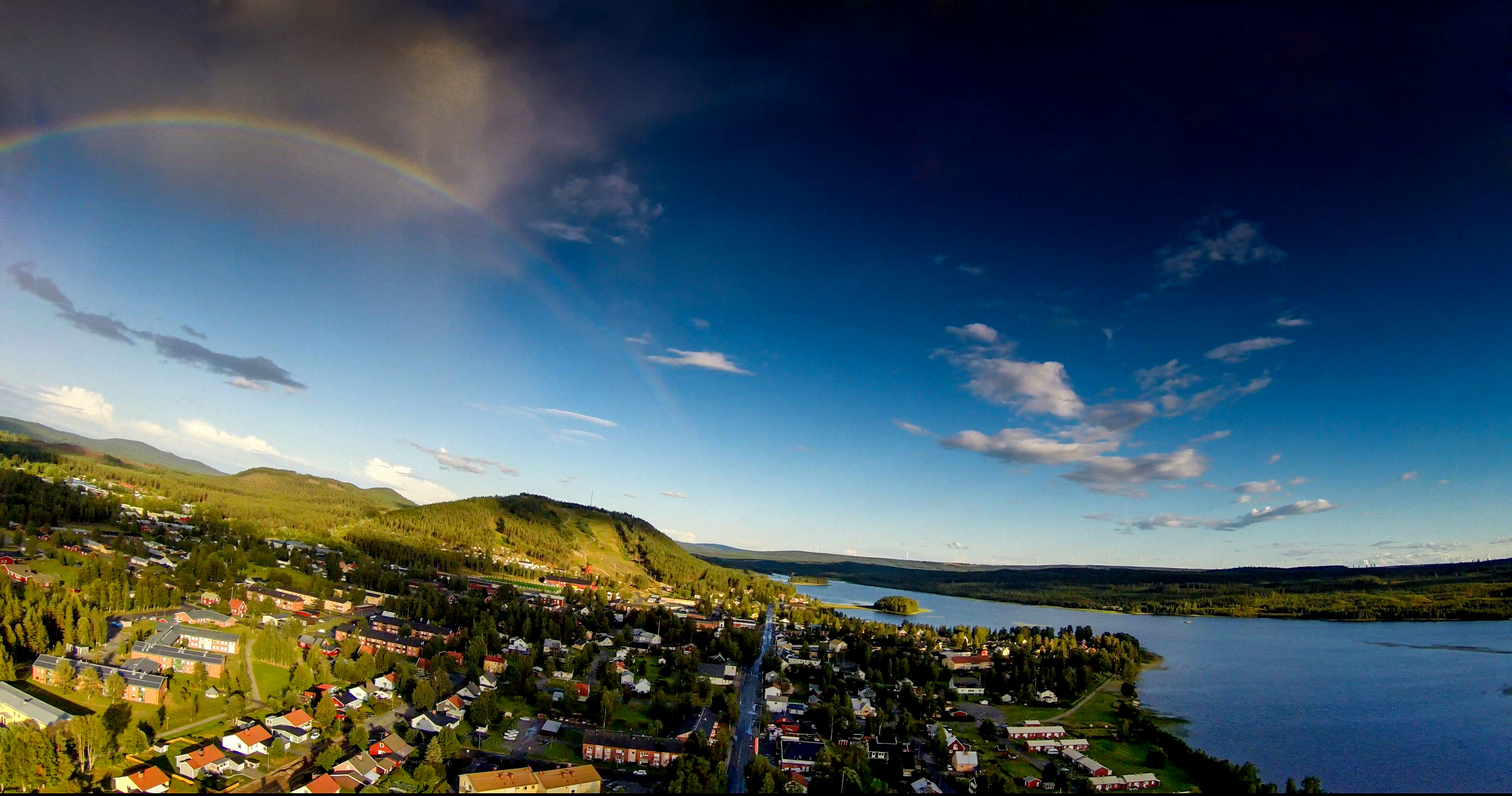 Flygfoto över Malå med Tjamstanbackarna i bakgrunden. Sommar. 